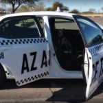 White taxi car with open doors parked in a lot